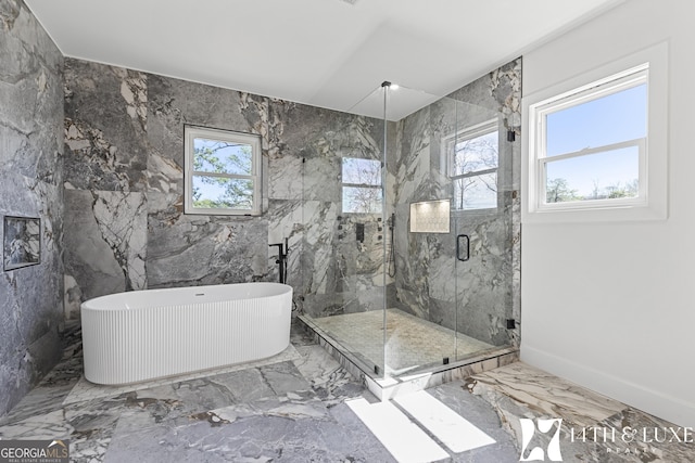 bathroom featuring marble finish floor, a freestanding tub, and a marble finish shower