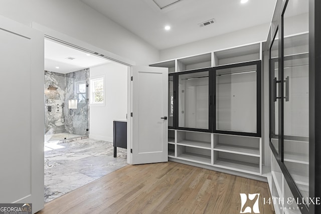 walk in closet with visible vents and wood finished floors