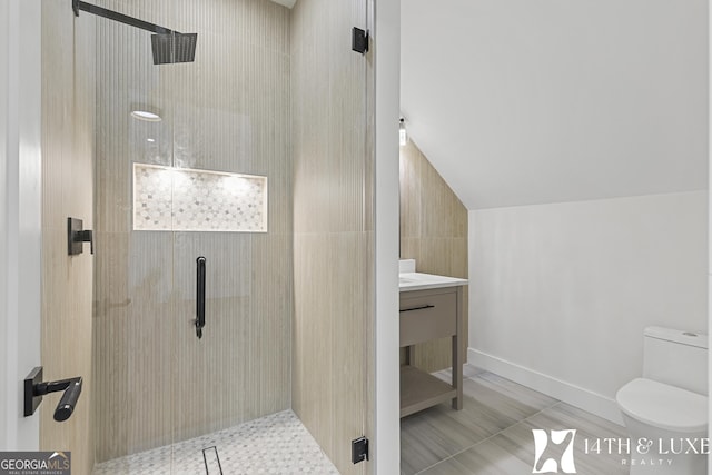 bathroom with vaulted ceiling, vanity, a shower stall, and toilet