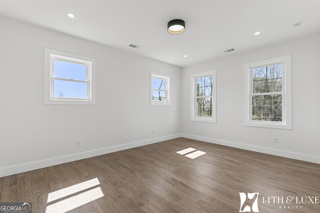 empty room with recessed lighting, wood finished floors, and baseboards