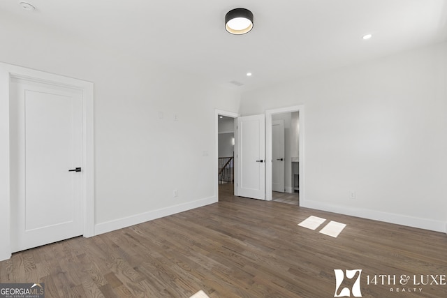 unfurnished bedroom featuring baseboards, wood finished floors, and recessed lighting