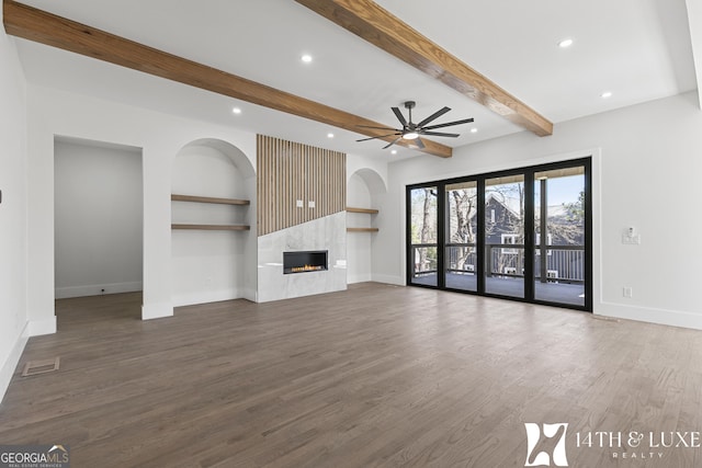 unfurnished living room with visible vents, a fireplace, baseboards, and wood finished floors