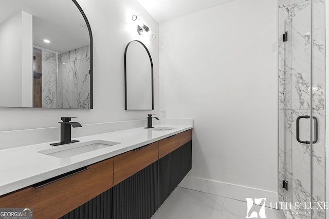 full bath featuring double vanity, a sink, a marble finish shower, and baseboards