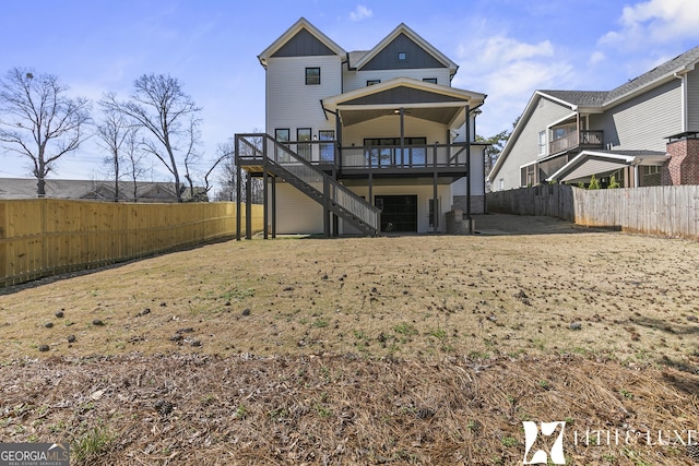 back of property featuring board and batten siding, a fenced backyard, stairway, and a wooden deck