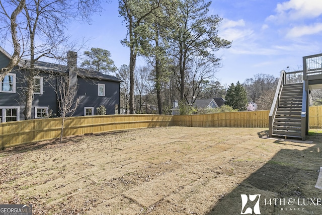 view of yard with fence and stairway