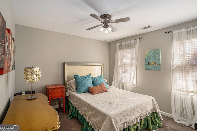 carpeted bedroom featuring visible vents, baseboards, and ceiling fan