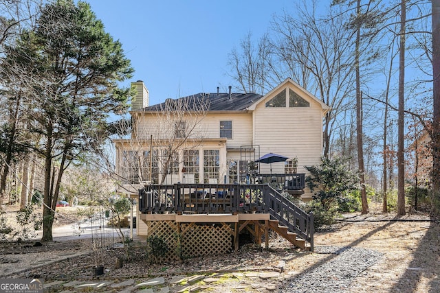 back of house featuring a chimney, stairs, and a deck