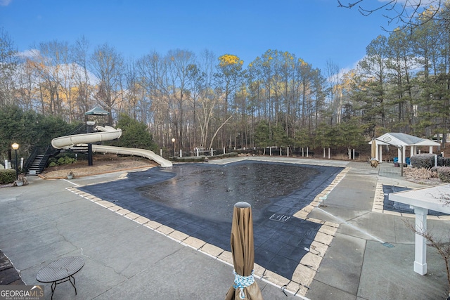 view of swimming pool featuring a patio and a water slide