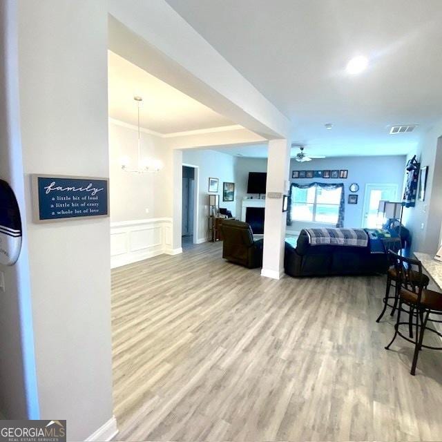 104 Eagle Heights Dr, Maysville, GA 30558 - living area featuring a wainscoted wall, visible vents, ceiling fan with notable chandelier, and wood finished floors