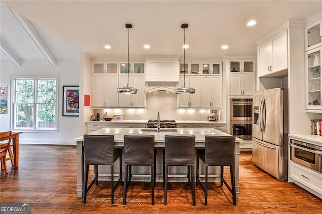 kitchen with stainless steel appliances, light countertops, a breakfast bar area, and tasteful backsplash