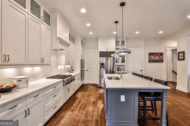 kitchen with stainless steel appliances, a breakfast bar, white cabinetry, and dark wood finished floors