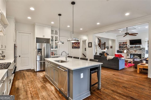 kitchen featuring stainless steel appliances, a sink, a ceiling fan, white cabinetry, and dark wood-style floors