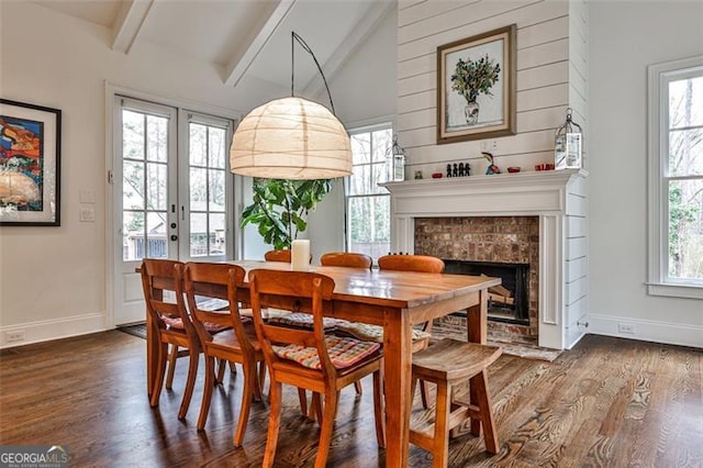 dining area with vaulted ceiling with beams, plenty of natural light, and dark wood finished floors