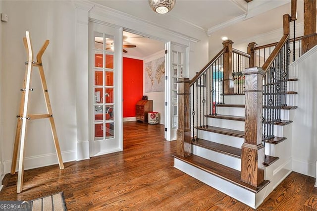 stairs with crown molding, baseboards, and wood finished floors