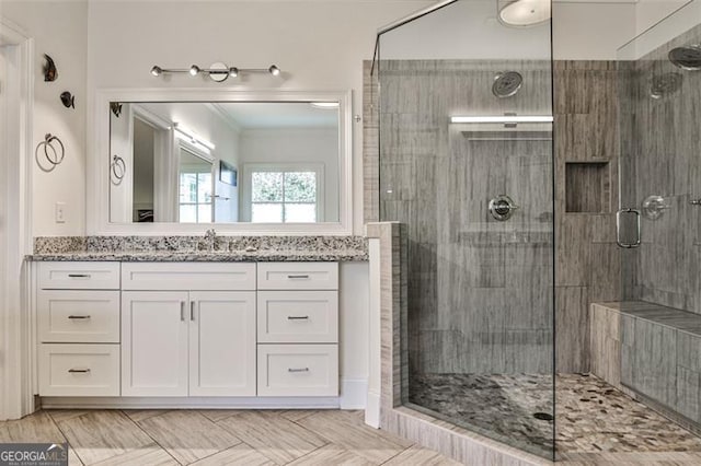 full bath featuring ornamental molding, a stall shower, and vanity