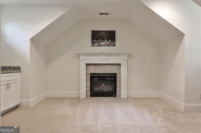 unfurnished living room featuring light carpet, a fireplace, visible vents, and vaulted ceiling