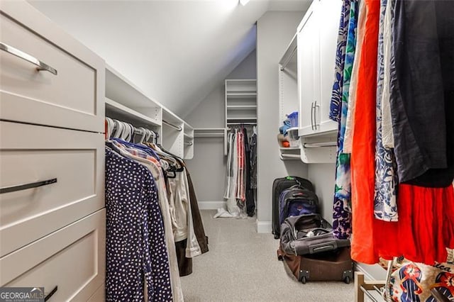 walk in closet with carpet floors and vaulted ceiling