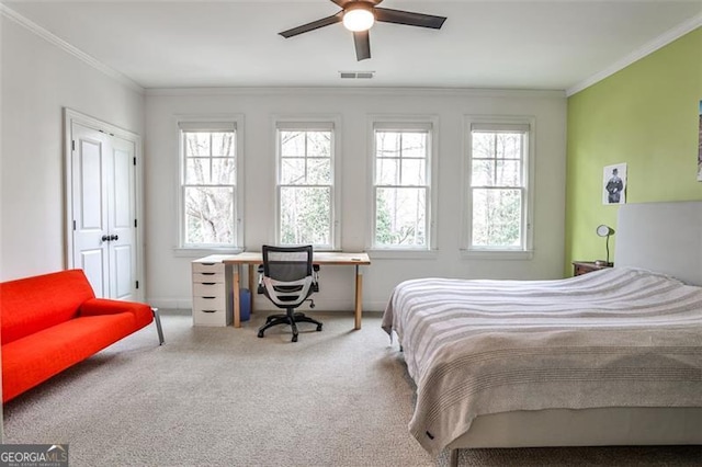 bedroom featuring carpet floors, ornamental molding, visible vents, and a ceiling fan