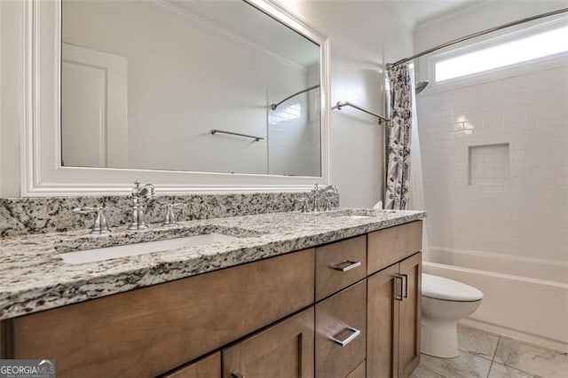 full bath featuring crown molding, a sink, toilet, and double vanity