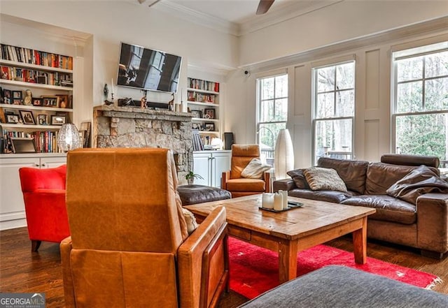 living area with a healthy amount of sunlight, built in features, crown molding, and wood finished floors