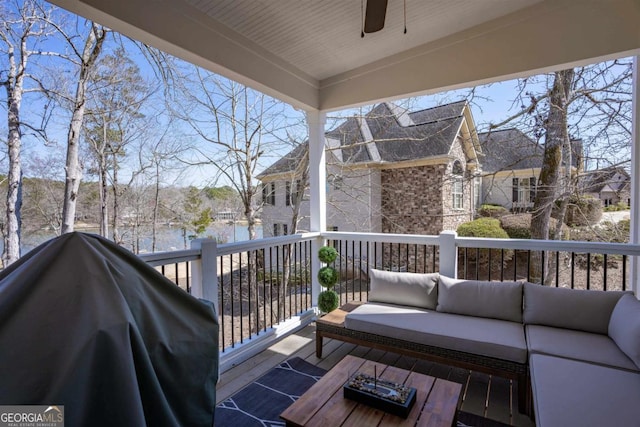 wooden terrace with ceiling fan, a grill, and an outdoor living space