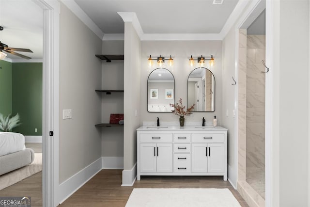 bathroom featuring tiled shower, a sink, and wood finished floors