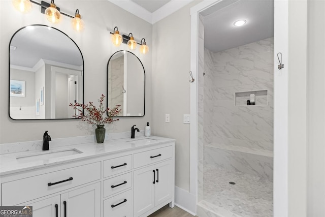 full bathroom featuring a sink, a tile shower, and double vanity