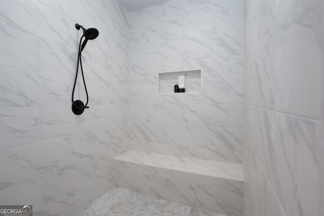 interior details featuring a tile shower