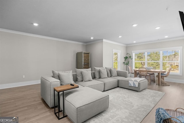 living room featuring ornamental molding, recessed lighting, baseboards, and wood finished floors