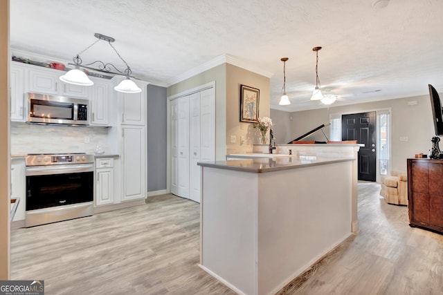 kitchen featuring light wood-type flooring, white cabinetry, appliances with stainless steel finishes, and a sink