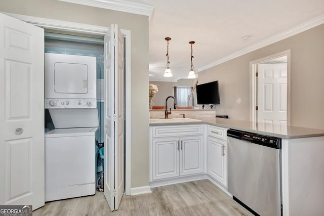 laundry room featuring laundry area, light wood finished floors, ornamental molding, stacked washing maching and dryer, and a sink