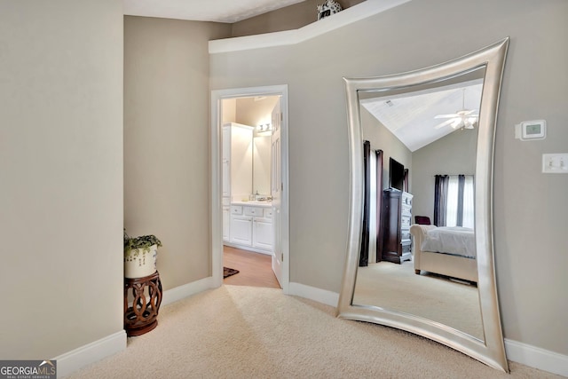 corridor with vaulted ceiling, carpet, and baseboards