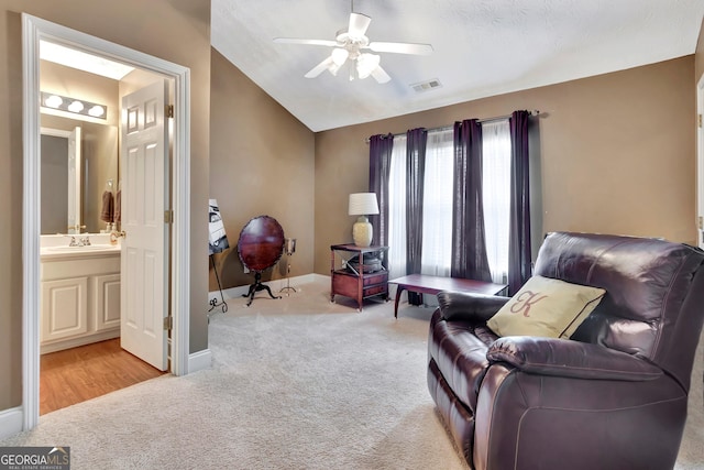 living area with carpet floors, baseboards, vaulted ceiling, and a ceiling fan