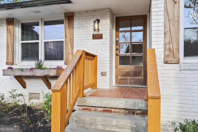 property entrance featuring brick siding