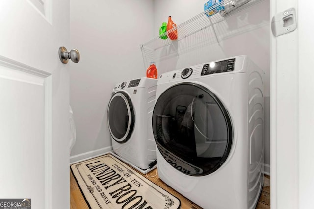 laundry room featuring laundry area, independent washer and dryer, baseboards, and wood finished floors