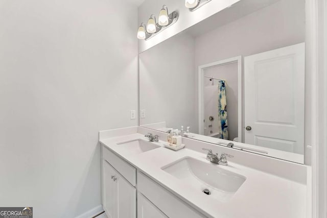 full bathroom with double vanity, shower / bath combo, baseboards, and a sink