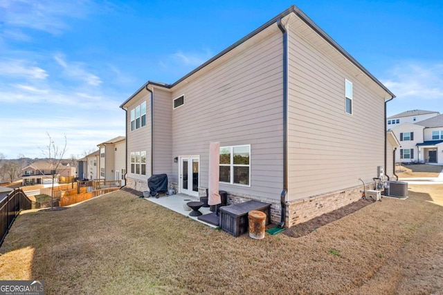 back of property with a lawn, a patio, fence, french doors, and central AC