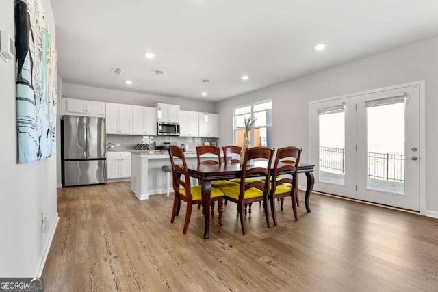 dining space with light wood-style flooring, visible vents, baseboards, and recessed lighting