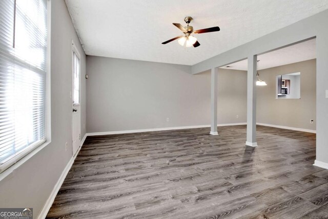 interior space featuring a ceiling fan, baseboards, and wood finished floors