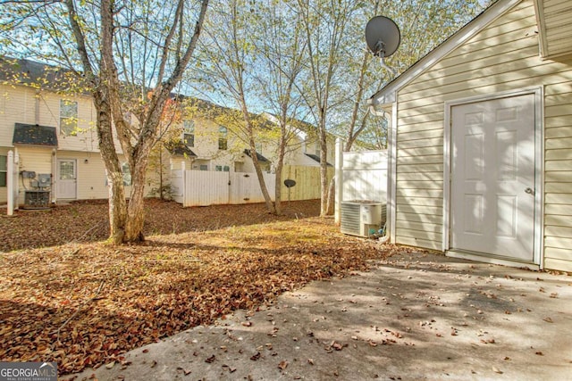 view of yard featuring fence and central air condition unit