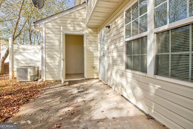 view of exterior entry with central air condition unit and a patio area