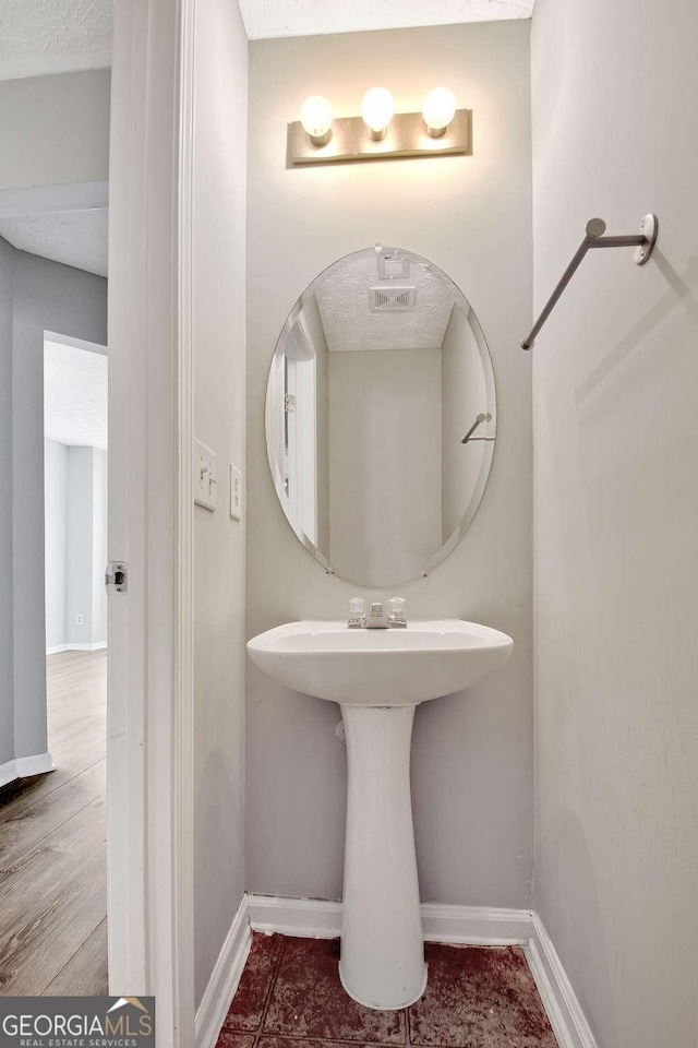 bathroom with a sink and baseboards