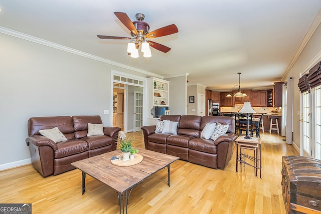 living room with ceiling fan, light wood-style flooring, baseboards, french doors, and crown molding