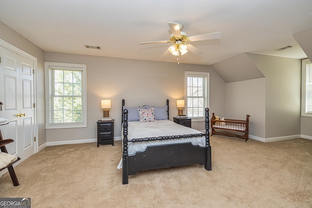 bedroom with visible vents, light carpet, and multiple windows