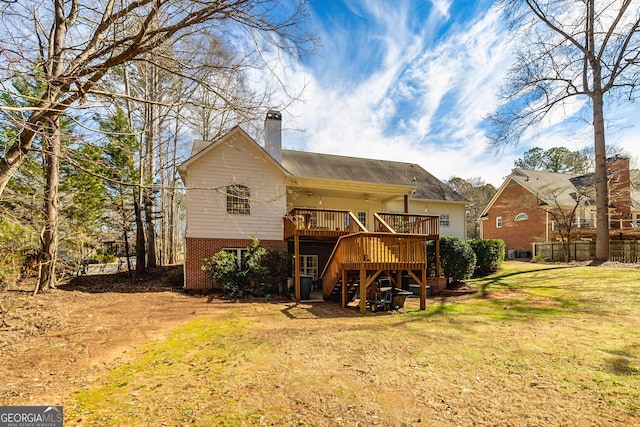 back of property featuring brick siding, a yard, stairway, a wooden deck, and a chimney