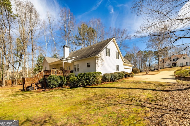 view of property exterior featuring concrete driveway, a chimney, an attached garage, and a lawn