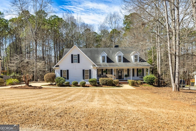 cape cod house featuring covered porch and a front lawn