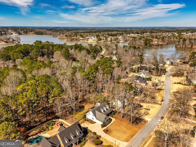 drone / aerial view featuring a water view and a wooded view