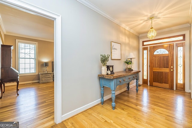 foyer entrance featuring light wood finished floors, baseboards, and crown molding