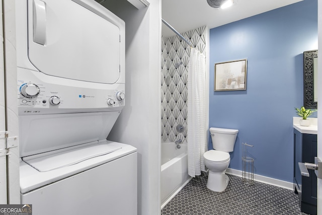 bathroom with stacked washer / drying machine, toilet, shower / bath combo with shower curtain, vanity, and baseboards